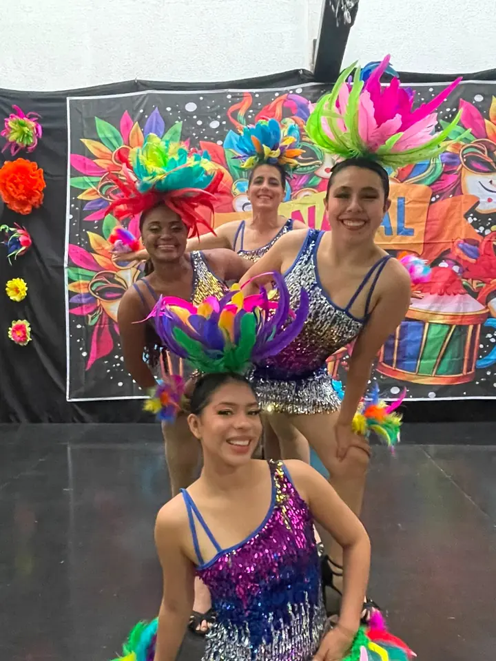Integrantes del Elenco Danzarte en escena con trajes de lentejuelas y tocados de plumas de carnaval